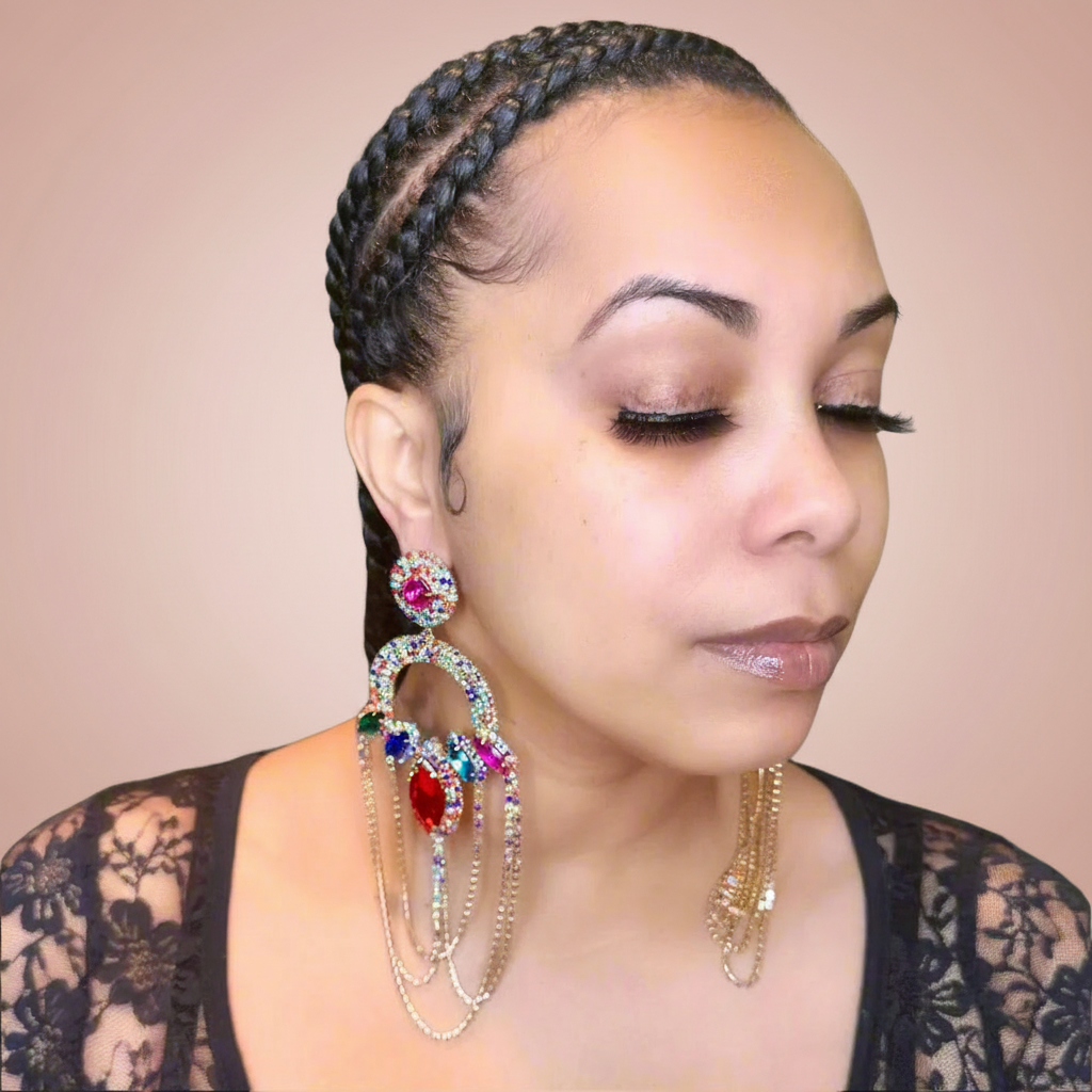Woman wearing large, colorful earrings against a beige background
