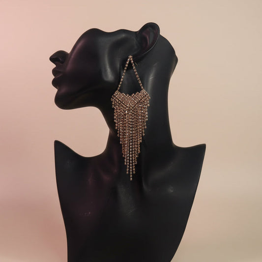 Earring on a black mannequin head with a beige background