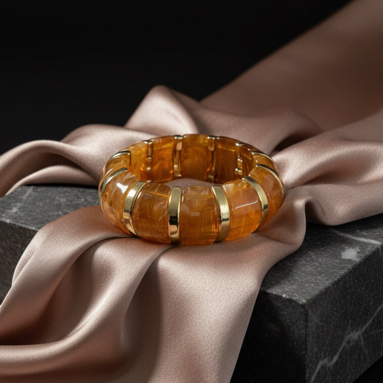 Decorative stone bangle on a dark surface with a tiled wall background