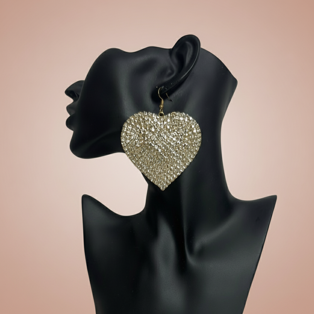 Adora Gold rhinestone Heart-shaped earrings on a black mannequin with a blush background