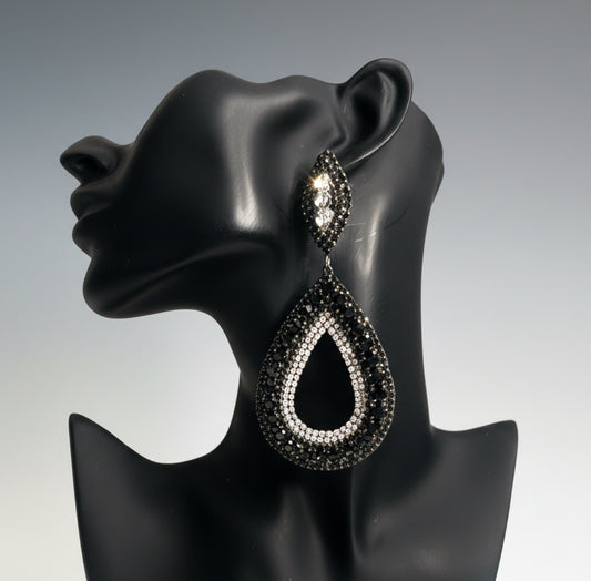 Black teardrop earring on a black mannequin ear against a gray background