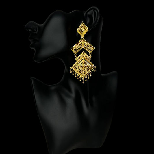 gold abstract earrings displayed on black mannequin with black background