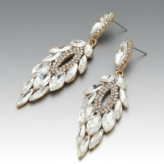 Pair of silver rhinestone ornate earrings with clear gemstones on a gray background