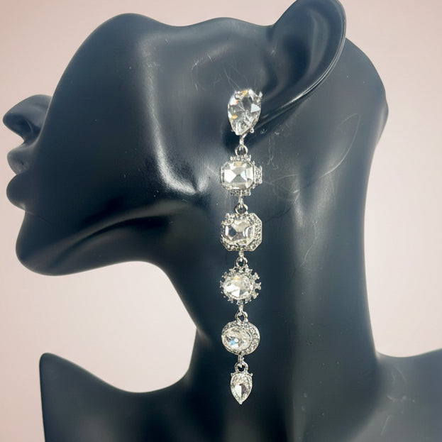 Rhinestone Dangling earrings on a black mannequin head against a beige background
