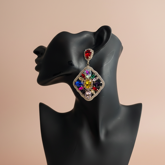 Multicolored gemstone earrings on a black mannequin bust against a beige background