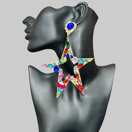 Multicolored star-shaped earrings on a black mannequin bust against a gray wall background.