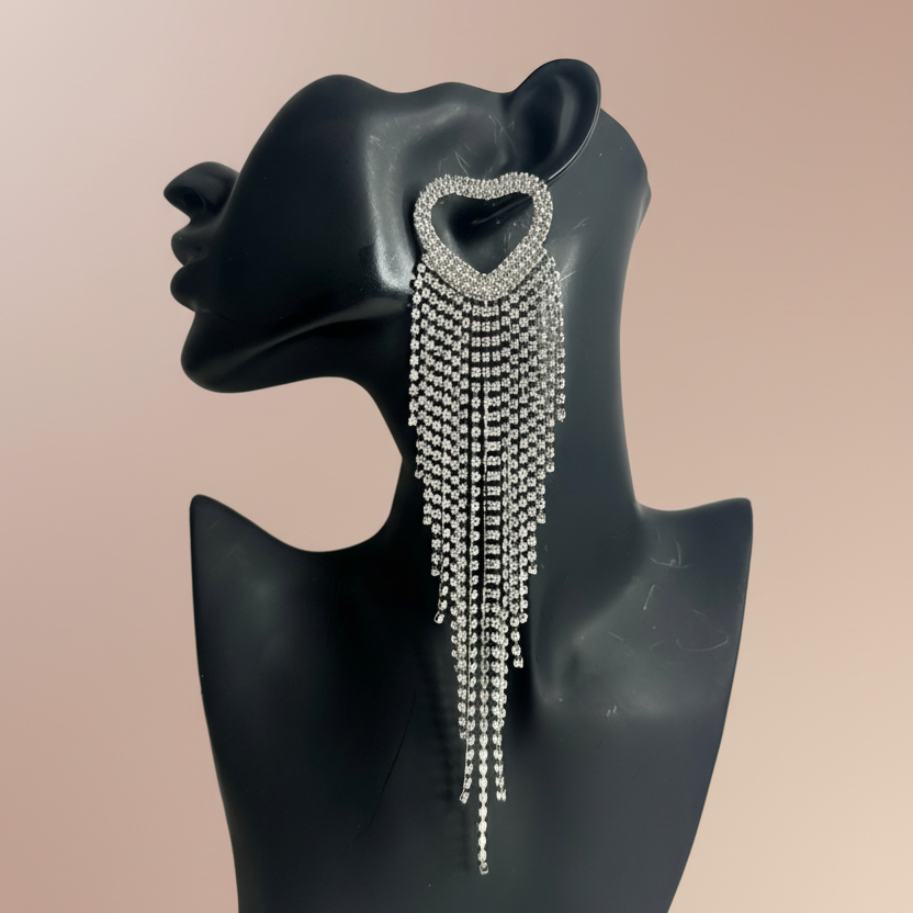 Elegant earring with dangling beads on a black mannequin bust against a beige background