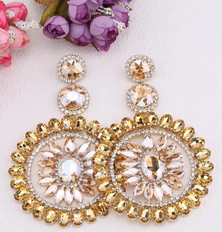 large gold chandelier earrings with citrine and champagne crystal sunburst design on blush nude background