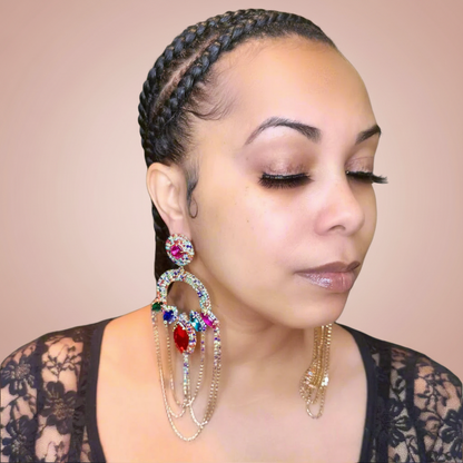 Woman wearing large, colorful earrings against a beige background