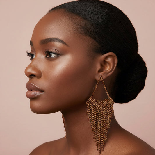 Bronze fringe earring on a model with a blush background 