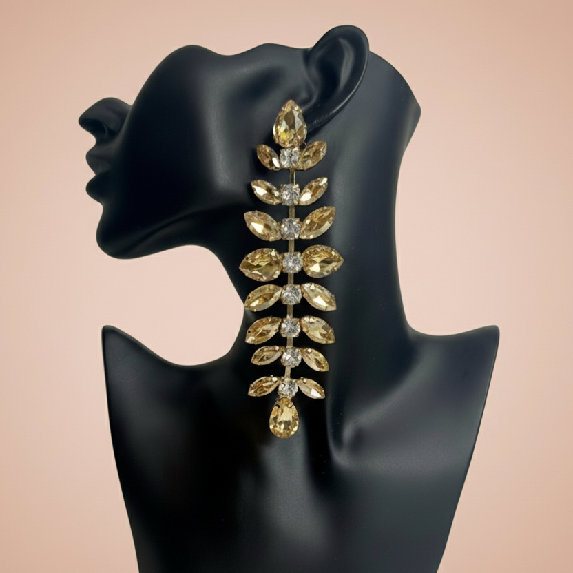 Gold and crystal earring on a black mannequin ear