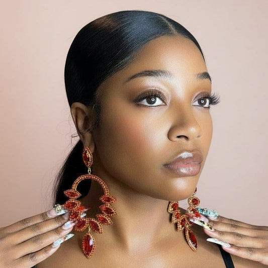 Woman wearing large, red ornate earrings against a neutral background