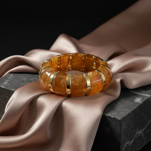Decorative stone bangle on a dark surface with a tiled wall background