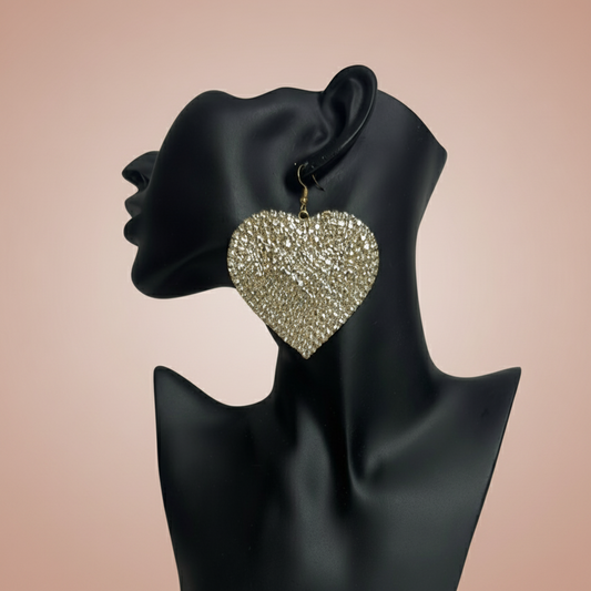 Adora Gold rhinestone Heart-shaped earrings on a black mannequin with a blush background