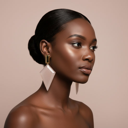 woman wearing  beige and gold spike earring against a beige background