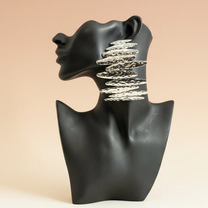 Silver cascading statement earrings displayed on a matte black mannequin bust against a neutral  background
