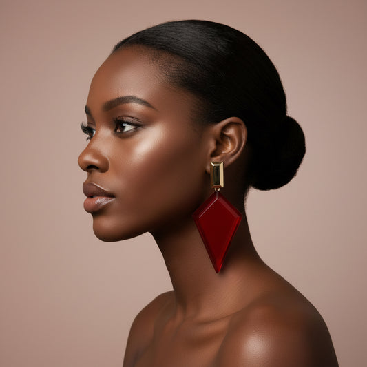Woman wearing red and gold spike earrings against a beige background