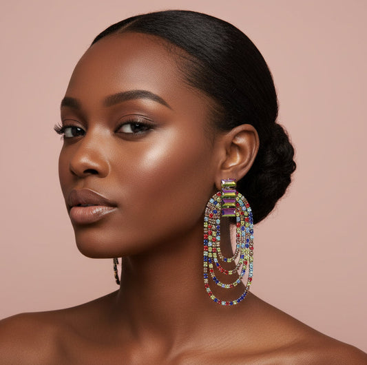 Woman wearing colorful beaded rhinestone earrings against a pink background