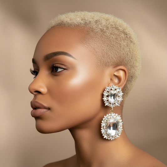 Woman wearing large, rhinestone ornate earrings against a neutral background