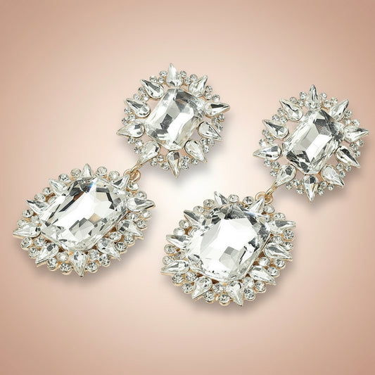 Pair of crystal earrings on a soft pink background