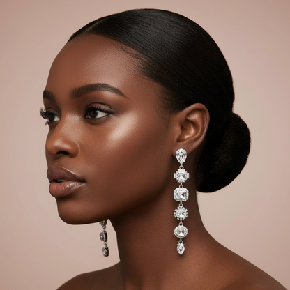Woman wearing elegant silver rhinestone dangle earrings with a soft pink background