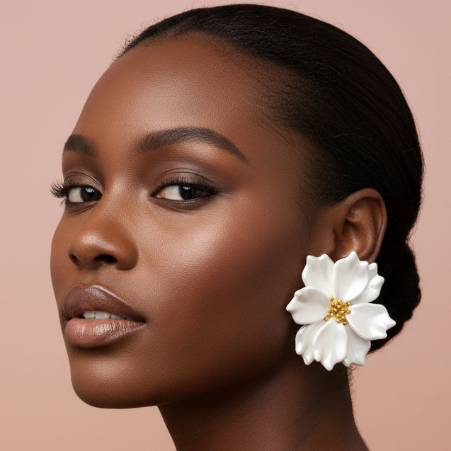 Woman wearing a white floral earring against a beige background