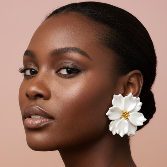 Woman wearing a white floral earring against a beige background