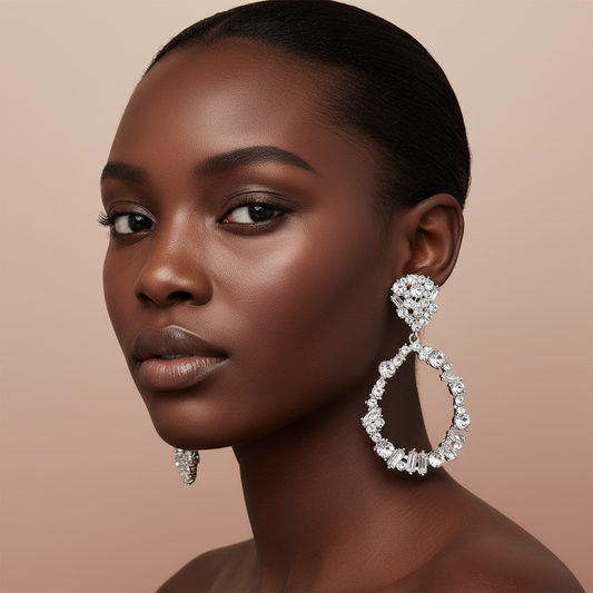 Woman wearing large, sparkling rhinestone circle earrings against a beige background